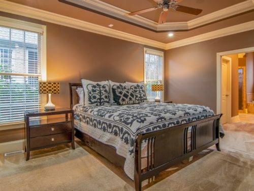 bed on wood flooring in light bedroom